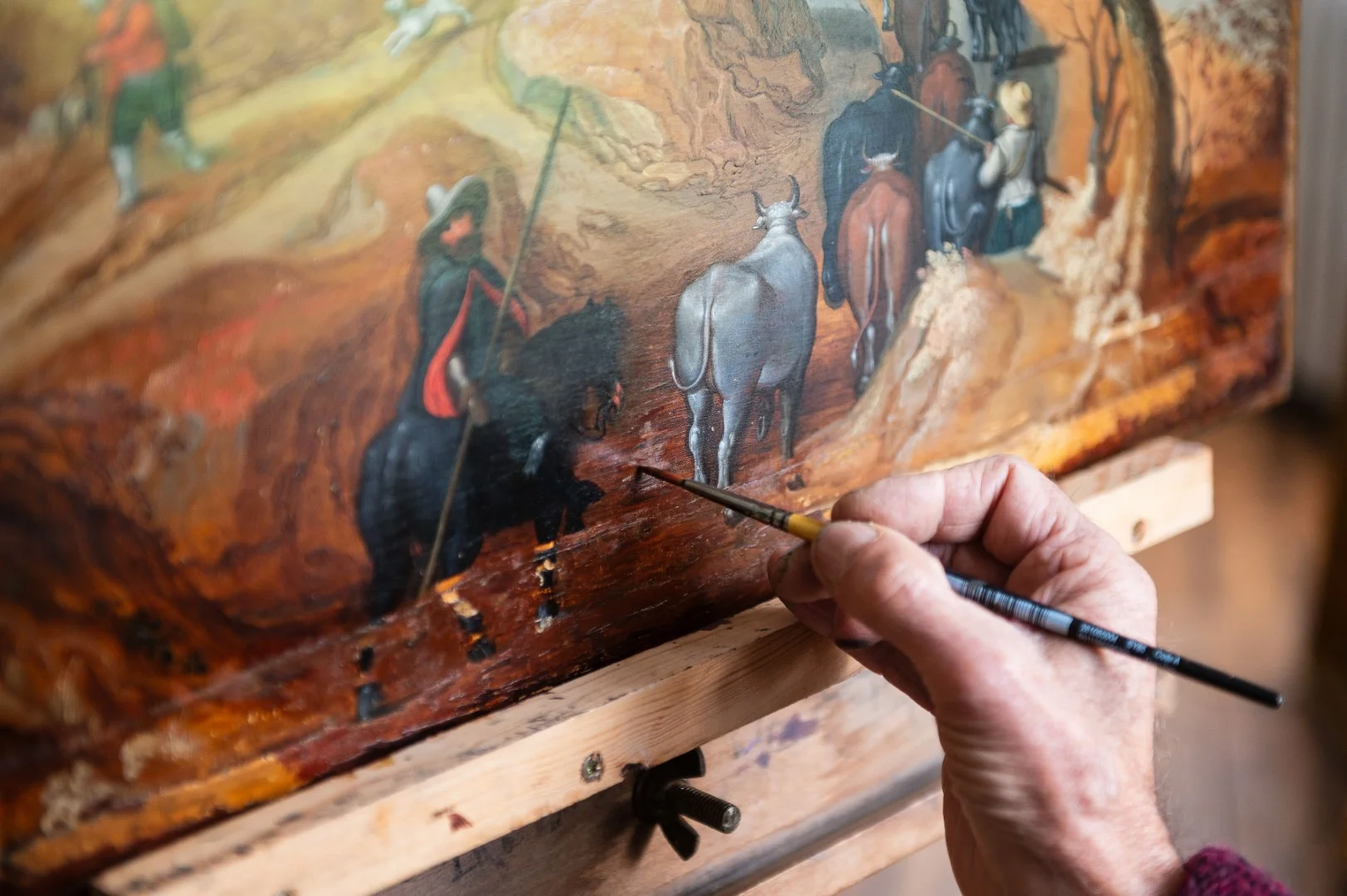 An old picture frame being tended to by a curator.